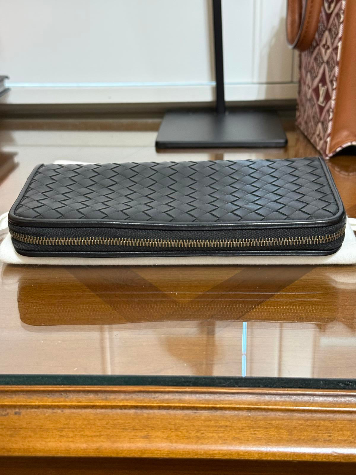 Bottega Veneta Intrecciato woven leather zip-around long wallet in black.