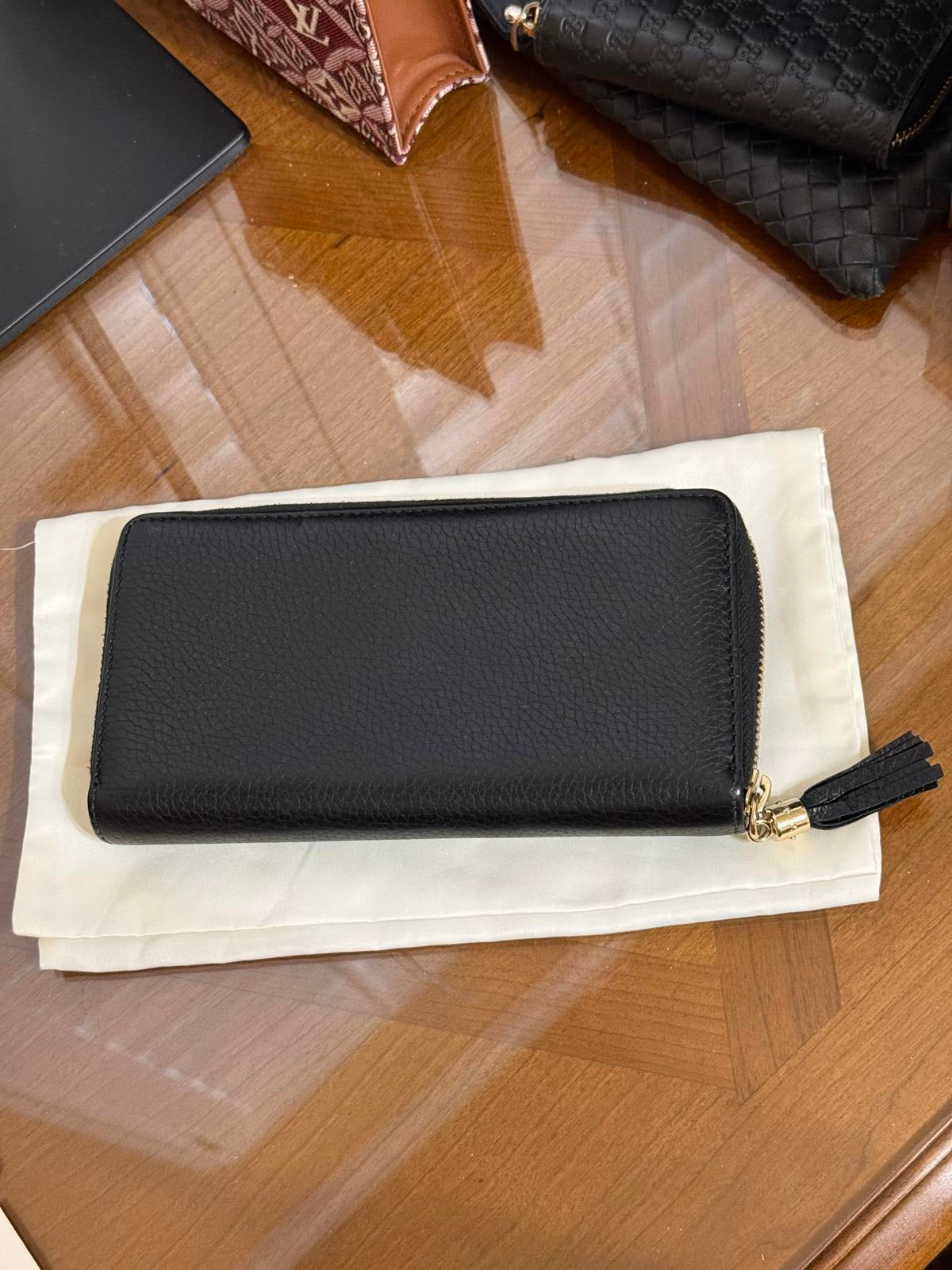 Gucci Soho zip-around long wallet in black pebbled leather with a tassel accent