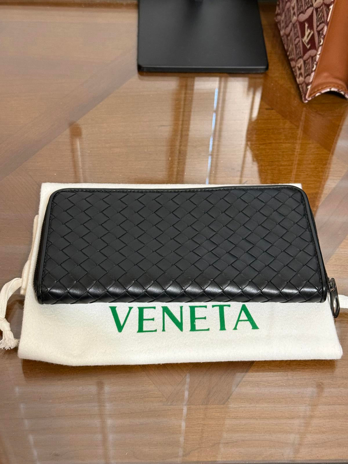 Bottega Veneta Intrecciato woven leather zip-around long wallet in black.